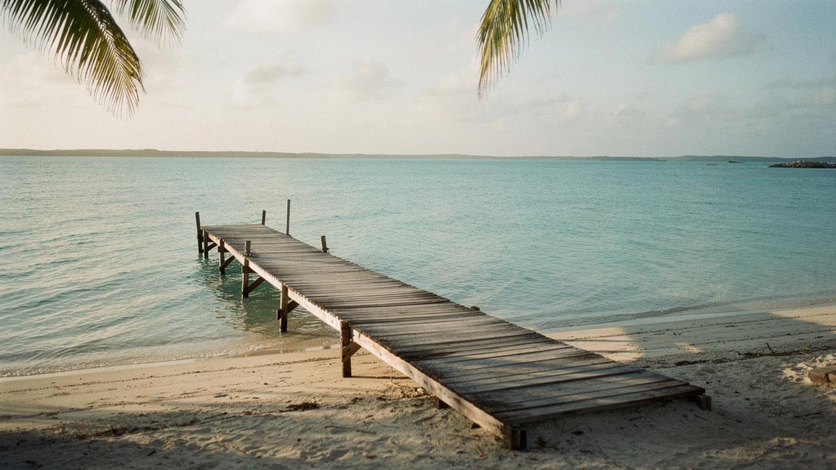 Turquoise lagoon with a wooden jetty leading to a small resort island